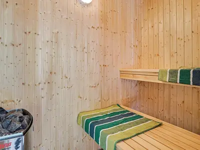 a sauna with a green and white towel on a shelf at 18 person holiday home in Fjerritslev in Fjerritslev