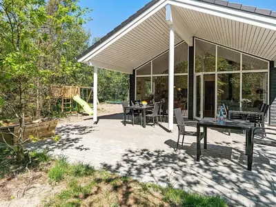 a patio with a table and chairs on it at 18 person holiday home in Fjerritslev in Fjerritslev