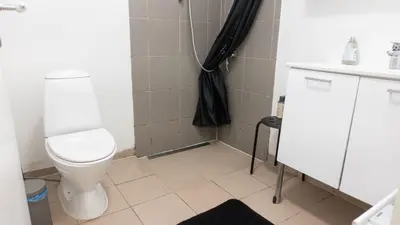 a bathroom with a toilet and a black shower curtain at Hilmor's Lejligheder in Viborg