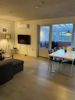a living room with a table and a tv at Hilmor's Lejligheder in Viborg