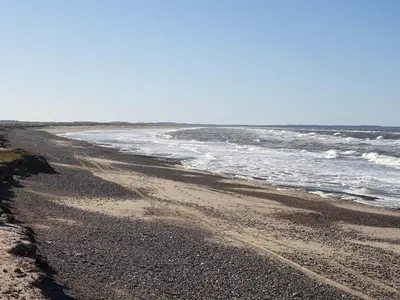 an empty beach with the ocean in the background at 6 person holiday home in Brovst in Brovst