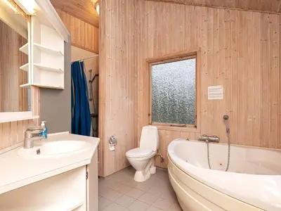 a bathroom with a tub and a toilet and a sink at 6 person holiday home in Fjerritslev in Fjerritslev