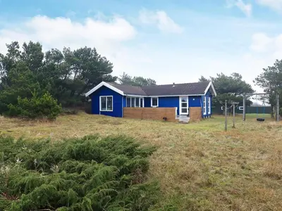 a blue house in the middle of a field at 6 person holiday home in Fjerritslev in Fjerritslev