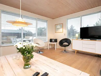 a living room with a television and a table with flowers at 6 person holiday home in Fjerritslev in Fjerritslev