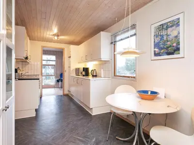 a kitchen with white cabinets and a table in a room at 6 person holiday home in Fjerritslev in Fjerritslev