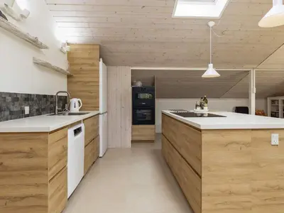 a kitchen with wooden cabinets and a counter top at Cozy Coastal Retreat in Gronhoj-By Traum in Løkken