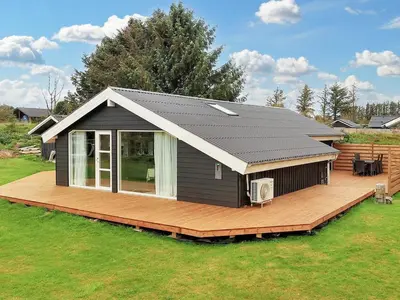 a small house with a deck and a roof at Cozy Coastal Retreat in Gronhoj-By Traum in Løkken