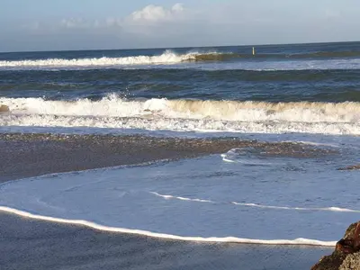 a beach with some waves in the ocean at 4 person holiday home in Fjerritslev in Fjerritslev