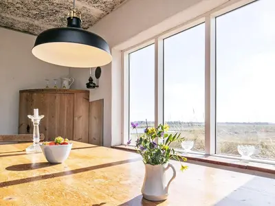 a dining room with a table with flowers on it at 4 person holiday home in Fjerritslev in Fjerritslev