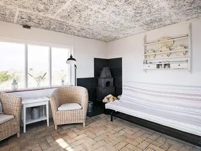 a room with a bench and two chairs and a fireplace at 4 person holiday home in Fjerritslev in Fjerritslev