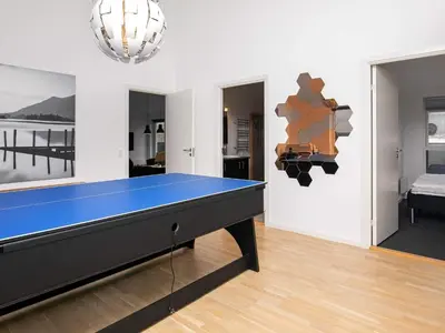 a ping pong table in a living room with at 6 person holiday home in Løkken in Løkken