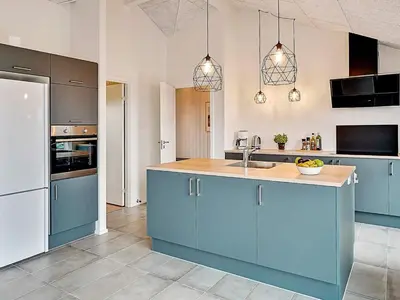 a kitchen with blue cabinets and a sink at 10 person holiday home in Løkken in Løkken