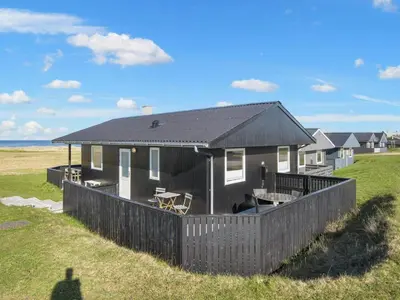 a house on the beach with a fence at Family Holiday Home by North Sea in Lemvig