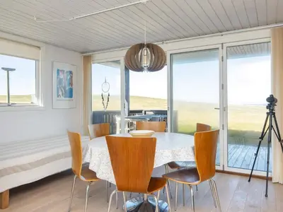 a dining room with a table and chairs at Family Holiday Home by North Sea in Lemvig