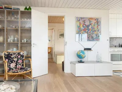 a living room with a glass table and a chair at Family Holiday Home by North Sea in Lemvig