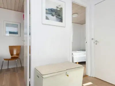 a room with a white door and a chair at Family Holiday Home by North Sea in Lemvig
