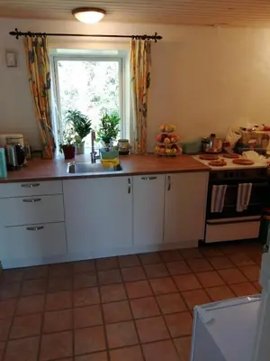a kitchen with white cabinets and a sink and a window at Stenhøj Bed and Breakfast, v. Jette og Marius in Erslev
