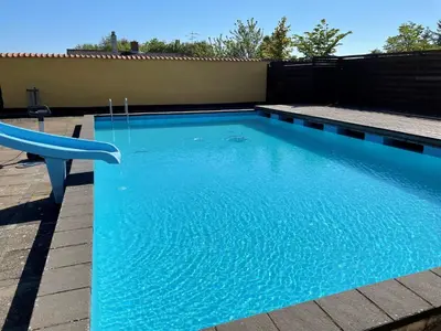 a large blue swimming pool with a chair in it at Bygholm Camping og aktiviteter in Vesløs