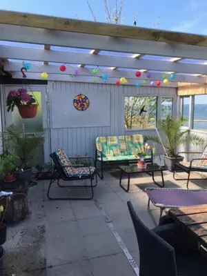 a patio with chairs and tables and a pergola at KristiansBorg in Nykøbing Mors