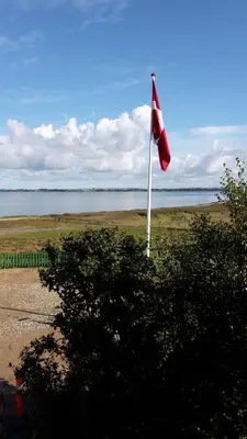 a red and white flag on a pole in a field at KristiansBorg in Nykøbing Mors