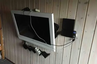 a television hanging on a wall with a video game controller at Beautiful and amazing view - 3 bedroom cottage in Vinderup