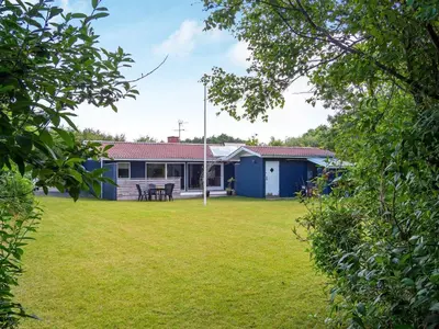 a house with a grass yard with a house at 6 person holiday home in Hurup Thy in Sønder Ydby
