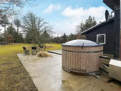 a large wooden tub sitting outside of a house at 6 person holiday home in Blokhus in Blokhus