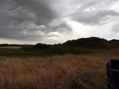 a field of grass with a cloudy sky at 6 person holiday home in Blokhus in Blokhus