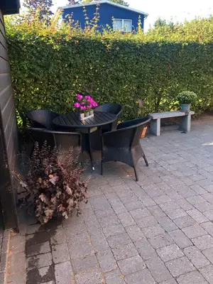 a patio with a table and two chairs and a bench at Nyistandsat højloftet kælderlejlighed på 70 m2 i Viborg centrum, med plads til 4 personer in Viborg