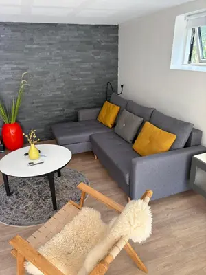 a living room with a couch and a table at Nyistandsat højloftet kælderlejlighed på 70 m2 i Viborg centrum, med plads til 4 personer in Viborg
