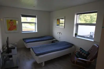 a room with two beds and a chair in it at Hellerup Bed & Breakfast in Løgstrup