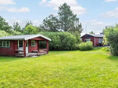 a small red house in a yard with a grass field at Secluded Retreat by Limfjorden - By Traum Ferienwohnungen in Sindrup