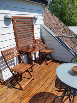 a wooden deck with two chairs and a table at Vejlen Bed & Kitchen in Vadum