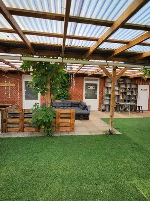 a wooden pergola in a backyard with a lawn at Løgstør Camping in Løgstør