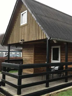 a log cabin with a bench on a deck at Løgstør Camping in Løgstør