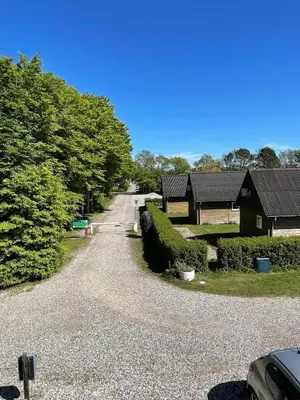 a gravel driveway leading to a house and a building at Løgstør Camping in Løgstør