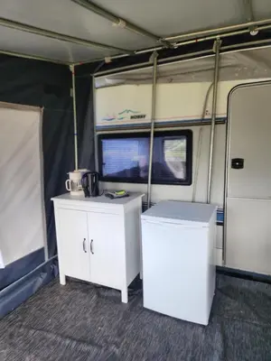 an interior of an rv with two white cabinets at Løgstør Camping in Løgstør