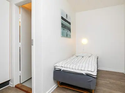 a small bedroom with a bed in the corner at Room in a holiday park- Type4 in Hanstholm