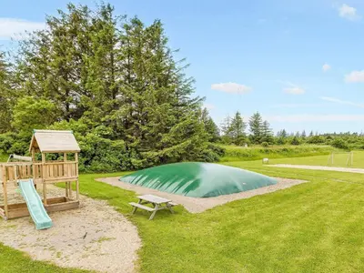 a small green pond with a gazebo and a bench at Room in a holiday park- Type4 in Hanstholm