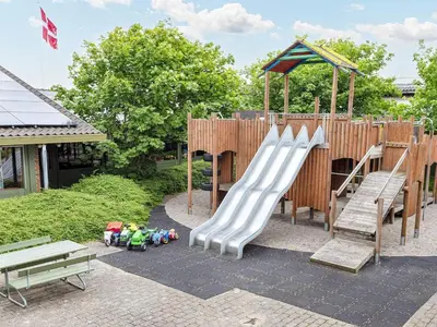 a childrens playground with a slide and benches at Room in a holiday park- Type4 in Hanstholm