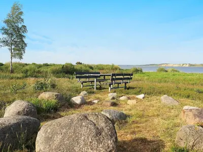 two benches sitting in a field with rocks at 6 person holiday home in Højslev-By Traum in Højslev