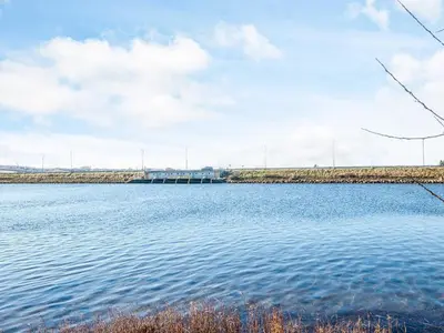 a large body of water with a bridge in the background at 6 person holiday home in Højslev-By Traum in Højslev