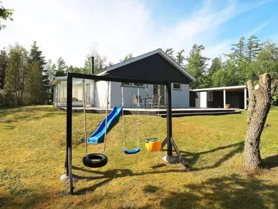 a swing set in a yard next to a house at 6 person holiday home in Højslev-By Traum in Højslev