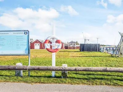 a sign sitting next to a bench in a field at 6 person holiday home in Højslev-By Traum in Højslev