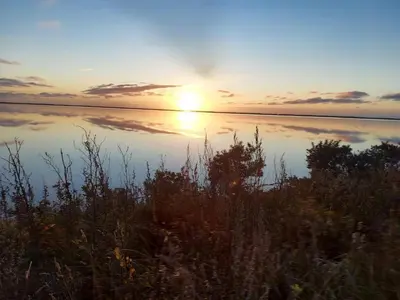 a sunset over a body of water with the sun setting at 6 person holiday home in Vestervig-By Traum in Vestervig