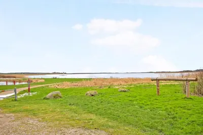 a park with a bench and a body of water at Ferielejlighed ved Vilsted Sø in Løgstør