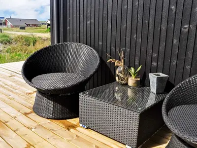 two wicker chairs and a table on a deck at 10 person holiday home in Harboøre-By Traum in Harboør
