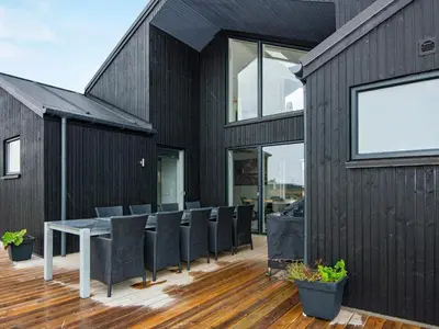 a black house with a table and chairs at 10 person holiday home in Harboøre-By Traum in Harboør
