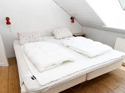 a bed with white sheets and pillows in a room at 10 person holiday home in Thisted in Thisted