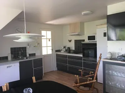 a kitchen with black and white cabinets and a window at Nationalpark Thy guesthouse in Vestervig
